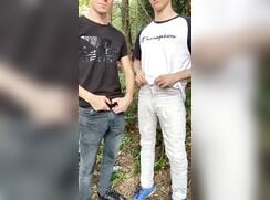 2 guy piss together in the woods